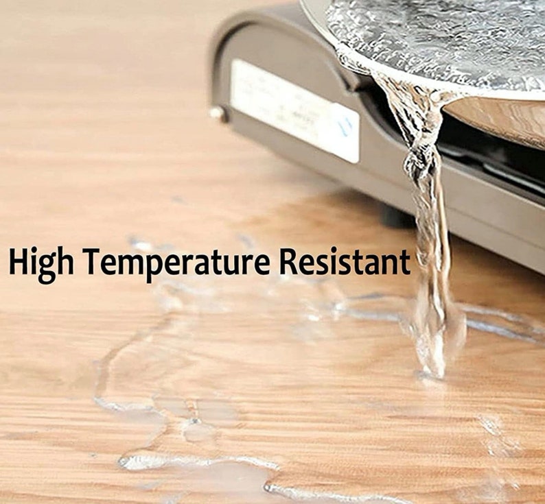Peut inclure: Gros plan sur un comptoir gris avec de l'eau qui coule d'une casserole en m&eacute;tal. Le texte "High Temperature Resistant" est visible sur l'image.