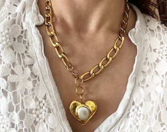 Colar com corrente grossa dourada em formato de coração e pingente de pérola barroca.