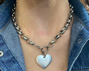 May include: A silver chain necklace with a large silver heart pendant.