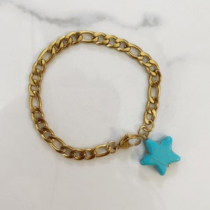 May include: A gold chain bracelet with a turquoise star charm.