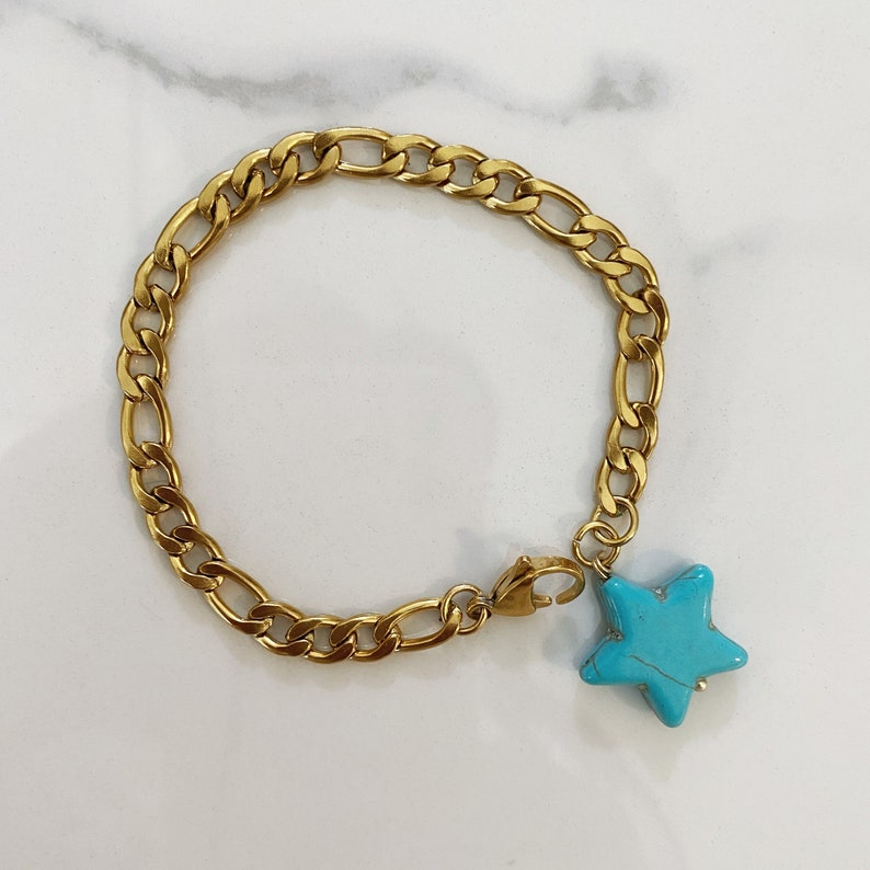 May include: A gold chain bracelet with a turquoise star charm.