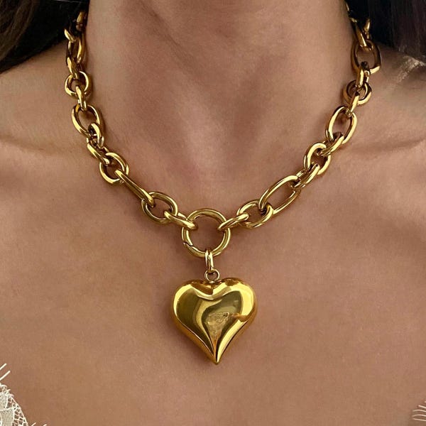 Collar con colgante grueso en forma de corazón abombado, cadena de acero tono dorado y colgante extraíble.