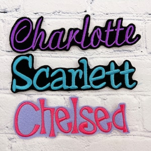 May include: Three embroidered iron-on patches with the names "Charlotte", "Scarlett", and "Chelsea" in different colors and fonts.