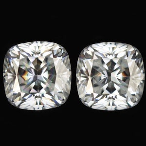 Op de afbeelding: Twee heldere kussen geslepen edelstenen op een zwarte achtergrond.