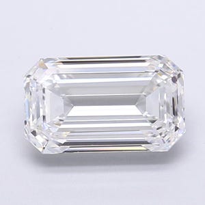 May include: A clear, emerald-cut diamond with a rectangular shape and beveled corners. The facets reflect light, creating a brilliant sparkle. The gemstone is set against a plain white background.