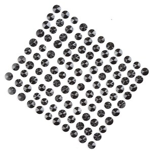 May include: A diamond-shaped arrangement of black rhinestones on a white background.