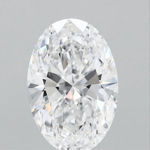 May include: A brilliant-cut, oval-shaped diamond. The gemstone is clear and colorless, with numerous facets that reflect light. The diamond is set against a plain, light gray background, highlighting its sparkle and clarity. The overall shape is elongated.