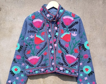 May include: A blue embroidered jacket with floral patterns in shades of pink, red, green, and black. The jacket has a mandarin collar and a button closure.