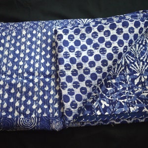 Puede incluir: Una colcha kantha azul y blanca con una variedad de patrones, que incluyen lunares, hojas y espirales.