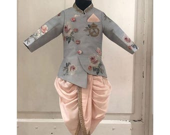 May include: A gray floral print jacket with a peach dhoti pant. The jacket has a mandarin collar and a button closure. The dhoti pant has a gold trim.