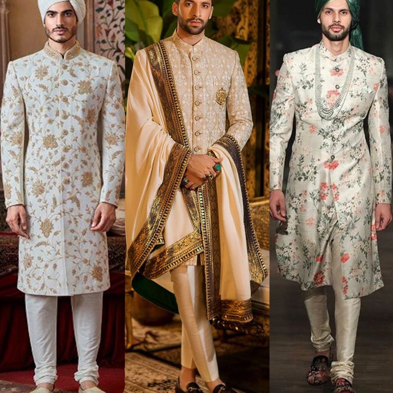 Op de afbeelding: Drie mannen in traditionele Indiase trouwjurken. De mannen dragen witte kurta's met bloemenborduurwerk, witte broeken en tulbanden. De kurta's zijn versierd met gouden borduurwerk. De mannen staan voor een achtergrond met een patroon.