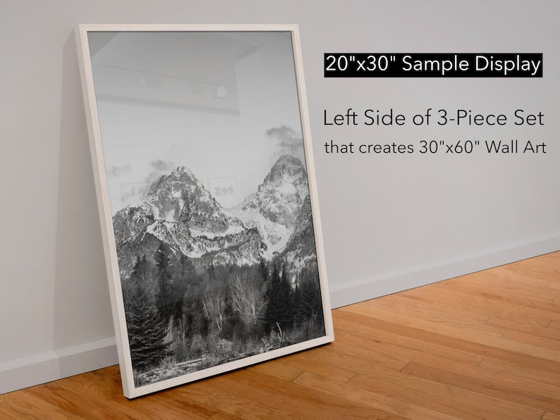 May include: A black and white photograph of a mountain range with snow-capped peaks. The image is framed in a white frame and is labeled "20"x30" Sample Display Left Side of 3-Piece Set that creates 30"x60" Wall Art".
