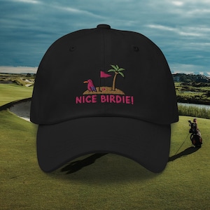 Könnte beinhalten: Schwarze Baseballkappe mit einem gestickten Design eines Cartoon-Vogels auf einem Golfplatz mit einer Palme und dem Text "NICE BIRDIE!"