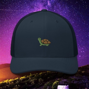 May include: A navy blue trucker hat with a green and brown embroidered turtle design.