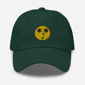 May include: A dark green baseball cap with a yellow smiley face embroidered on the front. The smiley face has black asterisks for eyes and a black line for a mouth.