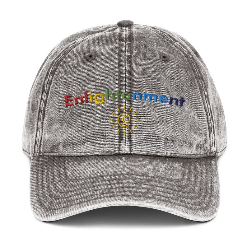K&ouml;nnte beinhalten: Eine schwarze, abgenutzte Baseballkappe aus Denim mit dem Wort "Enlightenment" in Regenbogenfarben gestickt. Unter dem Wort ist eine gelbe Sonne mit einem stilisierten "C" im Inneren gestickt.