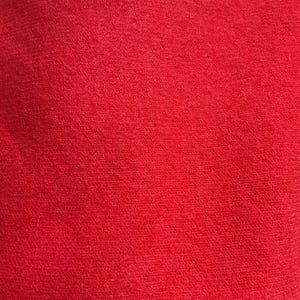May include: A close-up of a solid red fabric with a slightly textured surface.