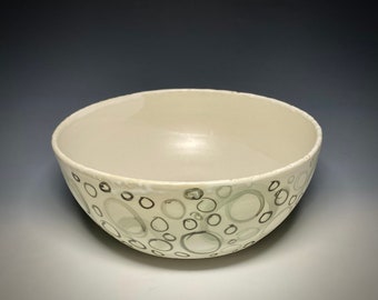 May include: A white ceramic bowl with a pattern of gray and black circles.