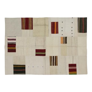 May include: Rectangular patchwork rug with a cream-colored background and various rectangular patches. The patches feature stripes in red, orange, brown, and green. The rug has a vintage, handcrafted aesthetic.