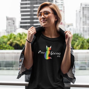 May include: A black t-shirt with a rainbow fox graphic and the text "Zero Given" in white lettering. The fox is sitting down with its tail curled around its body.