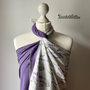 Può includere: Un bavaglino in mussola viola e bianco con stampa floreale lavanda. Il bavaglino è legato attorno a un manichino bianco.