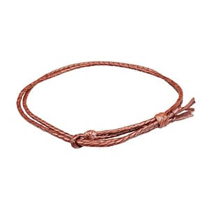 May include: A brown leather braided necklace with a knotted closure and dangling ends. The necklace is circular and appears to be made of multiple strands of leather woven together. The color is a warm, reddish-brown.