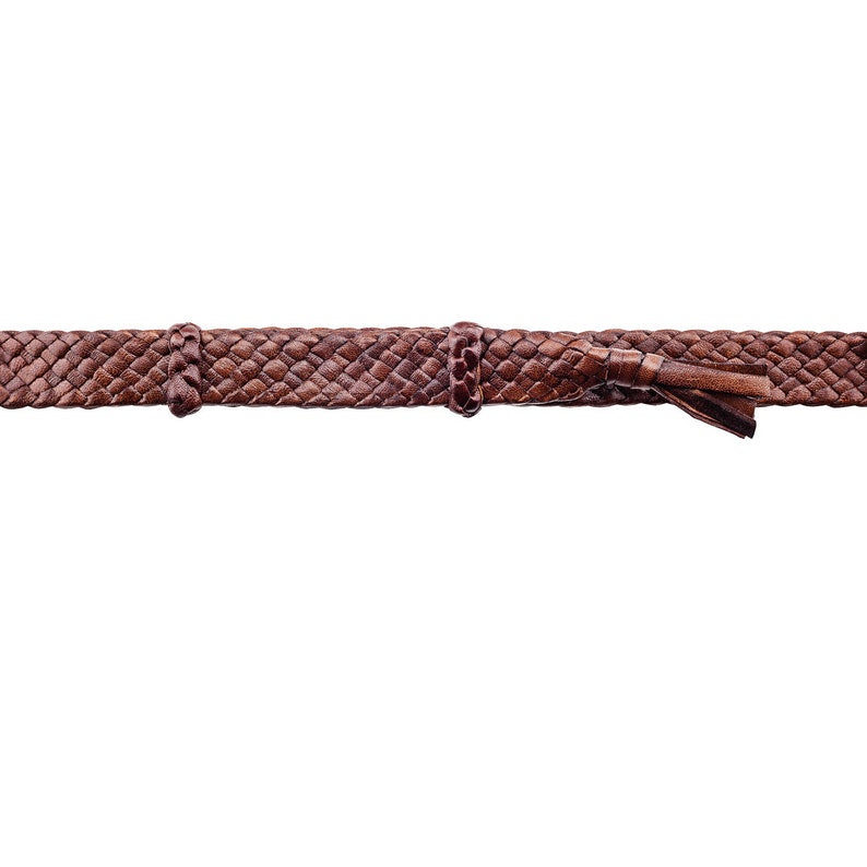 Peut inclure: Une ceinture en cuir tress&eacute; marron avec un motif tiss&eacute;. La ceinture a un pompon &agrave; une extr&eacute;mit&eacute; et deux boucles m&eacute;talliques.