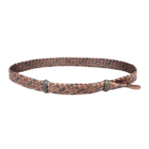 Peut inclure: Une ceinture en cuir tressée avec un motif tissé brun et noir. La ceinture a une boucle simple et une longue sangle fine.