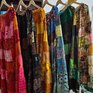 Pode incluir: Uma coleção de saias de patchwork coloridas penduradas em cabides. As saias são feitas de diferentes tecidos e padrões, incluindo desenhos florais, paisley e geométricos. As saias são todas longas e fluidas, e seriam perfeitas para um estilo boêmio ou hippie.