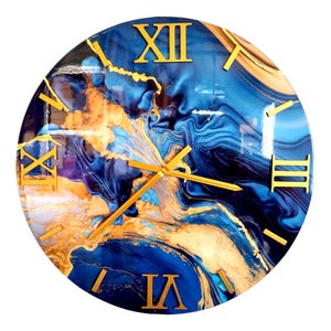 May include: Round wall clock with a blue and gold abstract design. The clock face features gold Roman numerals and hands. The background has a swirling pattern of blue and gold, creating a marbled effect.