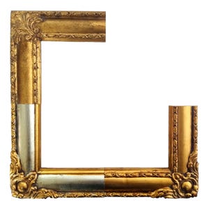 May include: Partial view of a gold and silver ornate picture frame. The frame has detailed carvings and a metallic finish. The design includes decorative corners and edges, showcasing a classic, vintage style. The frame is ideal for displaying artwork or photographs.