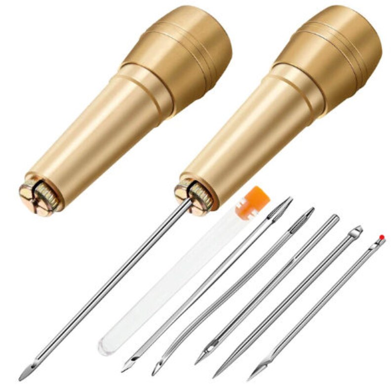 May include: Two gold-colored leather sewing awls with a set of six different sized needles. The needles are silver and come in a clear plastic tube.