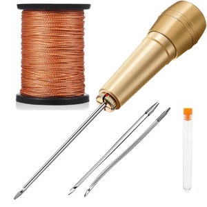 May include: A set of leather sewing tools including a gold awl, two needles, a spool of orange thread, and a clear plastic tube.