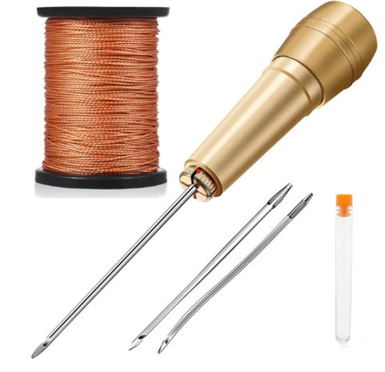 May include: A set of leather sewing tools including a gold awl, two needles, a spool of orange thread, and a clear plastic tube.