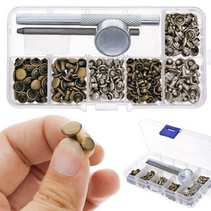 May include: A clear plastic box filled with various sizes of brass-colored metal rivets and a tool for setting them. The box also includes a hammer-like tool for setting the rivets.