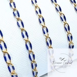 May include: Close-up of gold chain with blue enamel accents. The chain is made of small oval links. The chain is on a white surface. The text "Forever Linked" is visible in the lower right corner of the image.