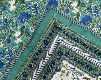 May include: A floral patterned quilt in shades of teal, blue, and white. The design features large blue and white flowers with green leaves on a teal background. The quilt has a teal border with a striped edge.
