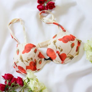 May include: A white ceramic mug with a black handle and the text "But First, Coffee" in a handwritten style. The mug is on a white surface. The mug is approximately 4 inches tall.