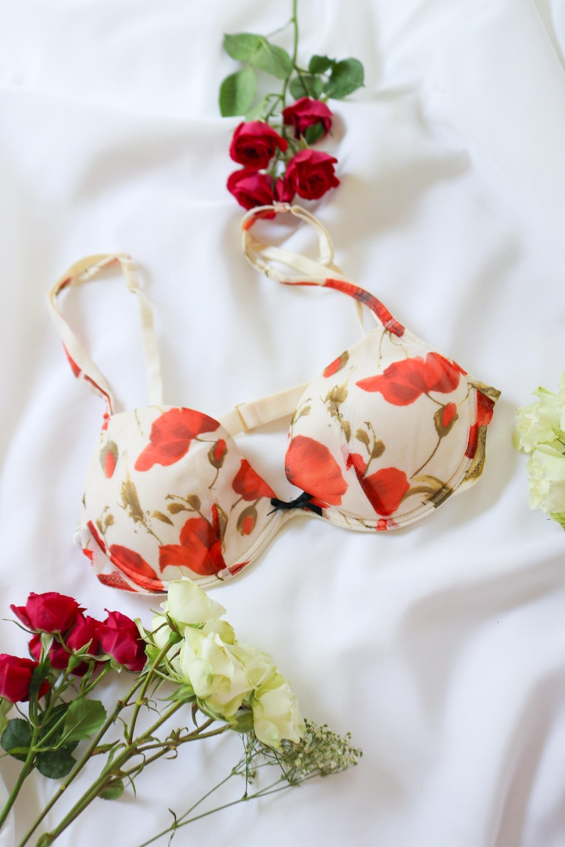 May include: A white ceramic mug with a black handle and the text "But First, Coffee" in a handwritten style. The mug is on a white surface. The mug is approximately 4 inches tall.