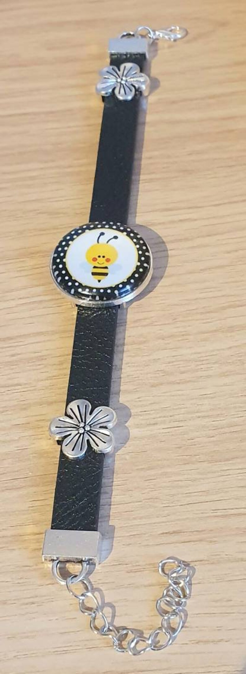 Black strap bracelet with a 25mm cute bee cabachon bezel.