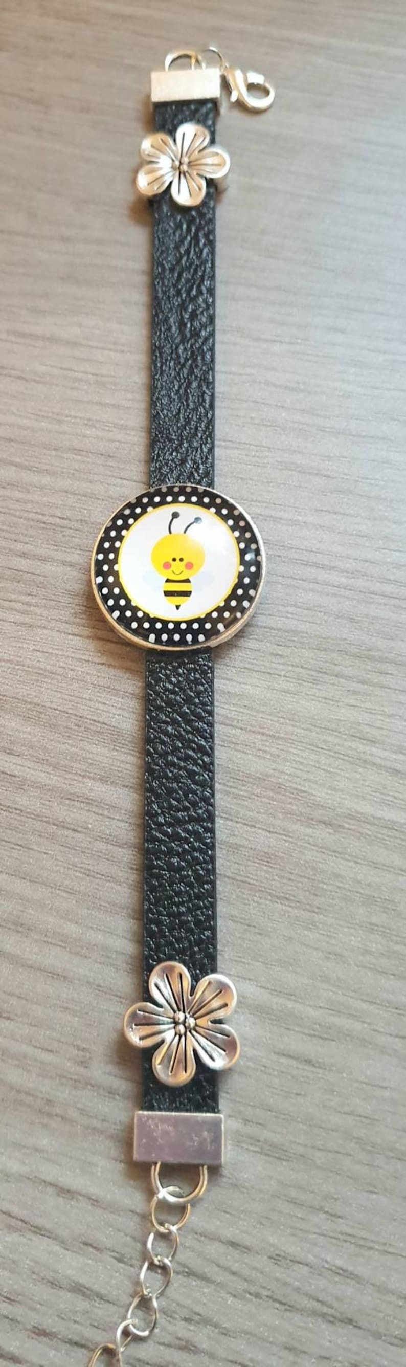 Black strap bracelet with a 25mm cute bee cabachon bezel.
