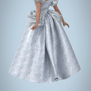 May include: A woman wearing a white gown with a floral pattern. The gown has a fitted bodice and a full skirt. The woman is standing with her back to the camera.
