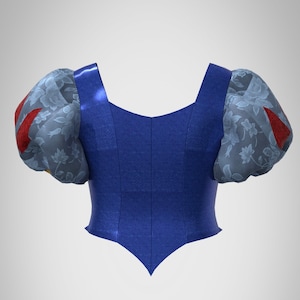 Puede incluir: Un corpi&ntilde;o azul con la parte inferior puntiaguda y mangas abullonadas. Las mangas son de color azul claro con un estampado floral y detalles rojos.