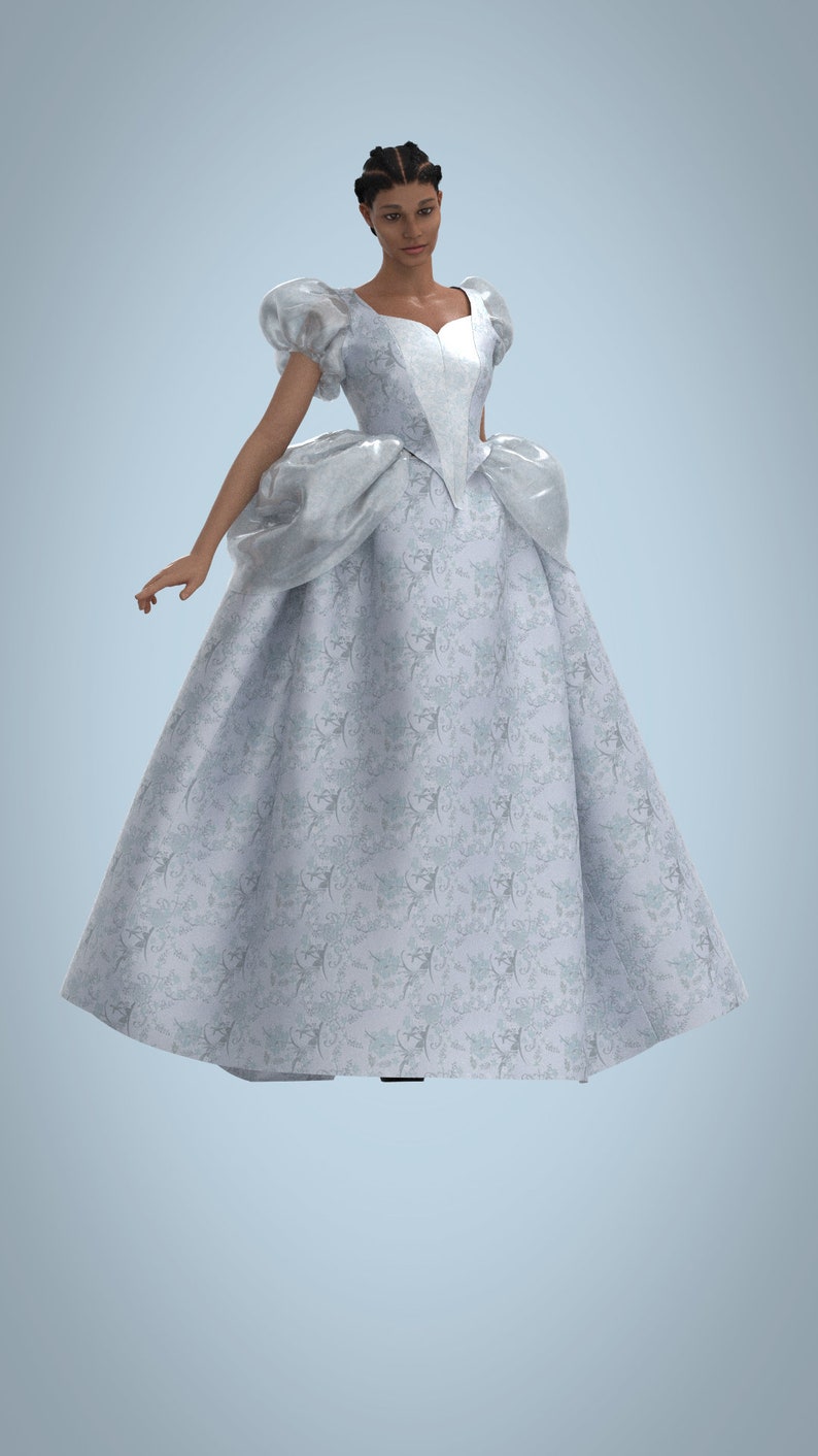 May include: A woman wearing a white ball gown with a floral pattern. The gown has a sweetheart neckline and puffed sleeves. The woman has dark skin and her hair is styled in braids.