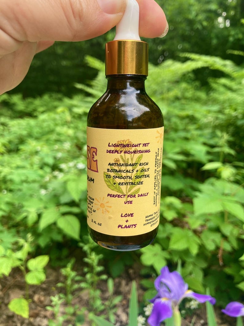 May include: A brown glass dropper bottle with a gold collar and white dropper top. The yellow label features a botanical illustration and text including Lightweight Yet Deeply Nourishing, Antioxidant Rich Botanicals + Oils, and 2 fl oz.