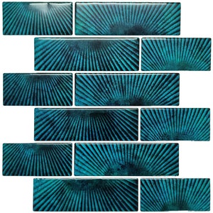 Pode incluir: Azulejo de cerâmica azul turquesa com um padrão de raios de sol. O azulejo é brilhante e tem uma superfície texturizada.