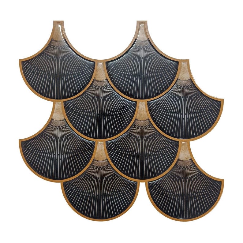 Black Egyptian peel-and-stick tile set in overlapping scallop shapes with tan borders for a 3D vinyl backsplash.