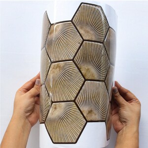 Light brown hexagon peel-and-stick tile sheet for kitchen backsplash; wood-look honeycomb pattern, self-adhesive vinyl tile.