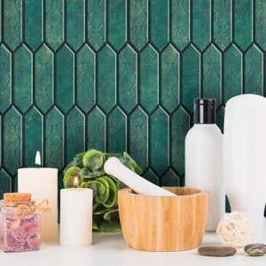 Vanity styling with candles and jars, emerald hexagon peel and stick tile forming a jewel-like bathroom backsplash