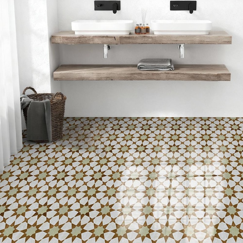 K&ouml;nnte beinhalten: Badezimmer-Interieur mit einem gemusterten Fliesenboden mit einem sich wiederholenden Sterndesign in Braun, Wei&szlig; und Gr&uuml;n. Der Raum umfasst ein Holzregal mit zwei wei&szlig;en Waschbecken, schwarzen Wasserh&auml;hnen und einem Weidenkorb.